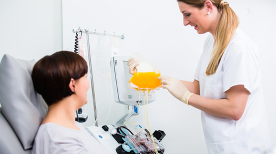 Phlebotomist with patient collecting plasma.