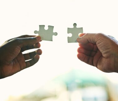 hands putting together two puzzle pieces